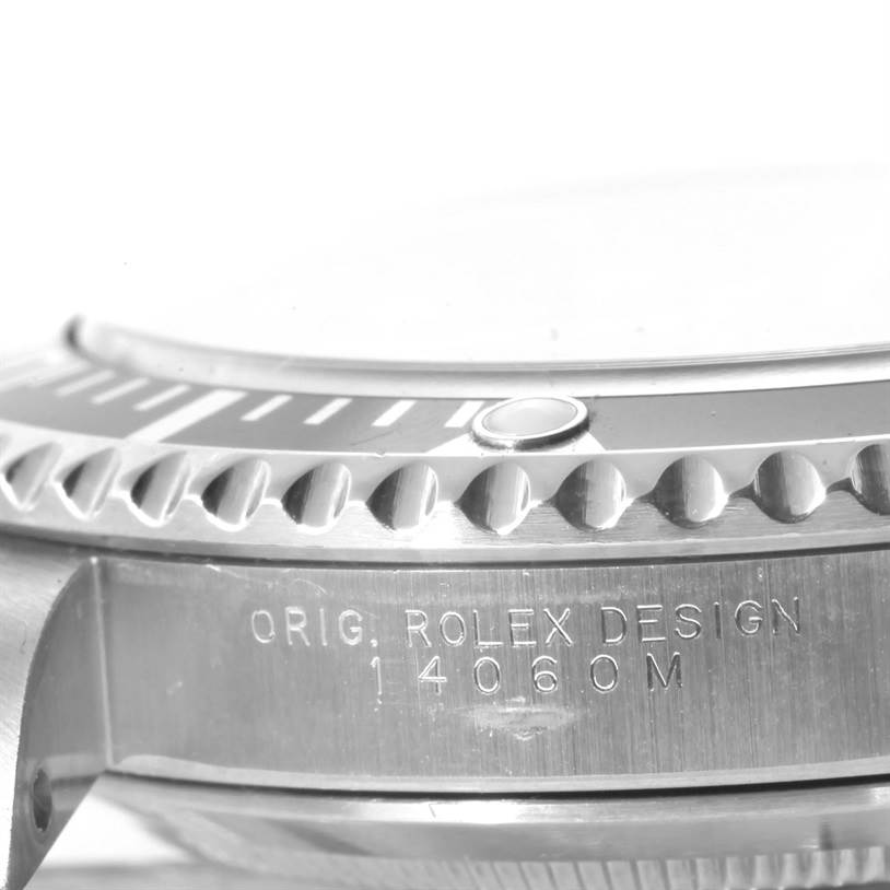 The image shows a close-up side angle of a Rolex Submariner 14060 Men
s Stainless Steel Black Dial 14060 Men
s Stainless Steel Black Dial watch, highlighting the bezel and engraved case markings.