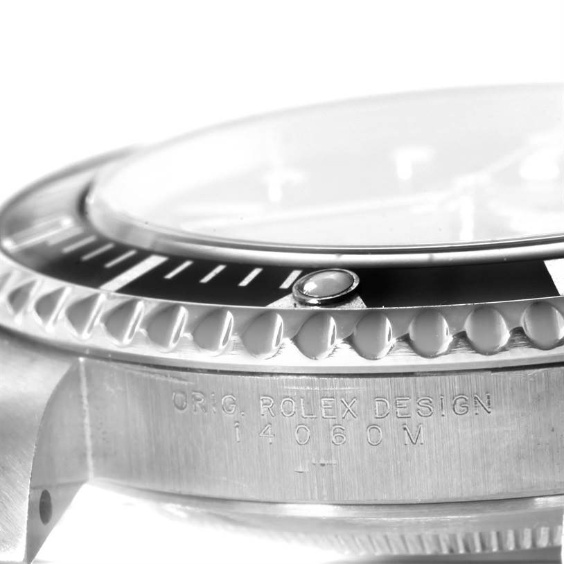 The image displays a close-up, angled view of the bezel, crystal, and engraved side of a Rolex Submariner 14060 Men
s Stainless Steel Black Dial 14060 Men
s Stainless Steel Black Dial watch.