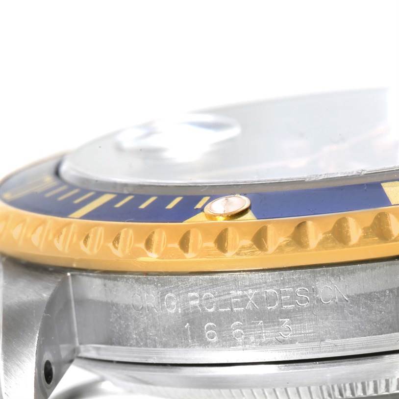 The image shows a close-up side view of the Rolex Submariner 16613 Men's Steel and Gold (two tone) Blue Dial 16613 Men's Steel and Gold (two tone) Blue Dial, highlighting the bezel and part of the case with model number engraving.