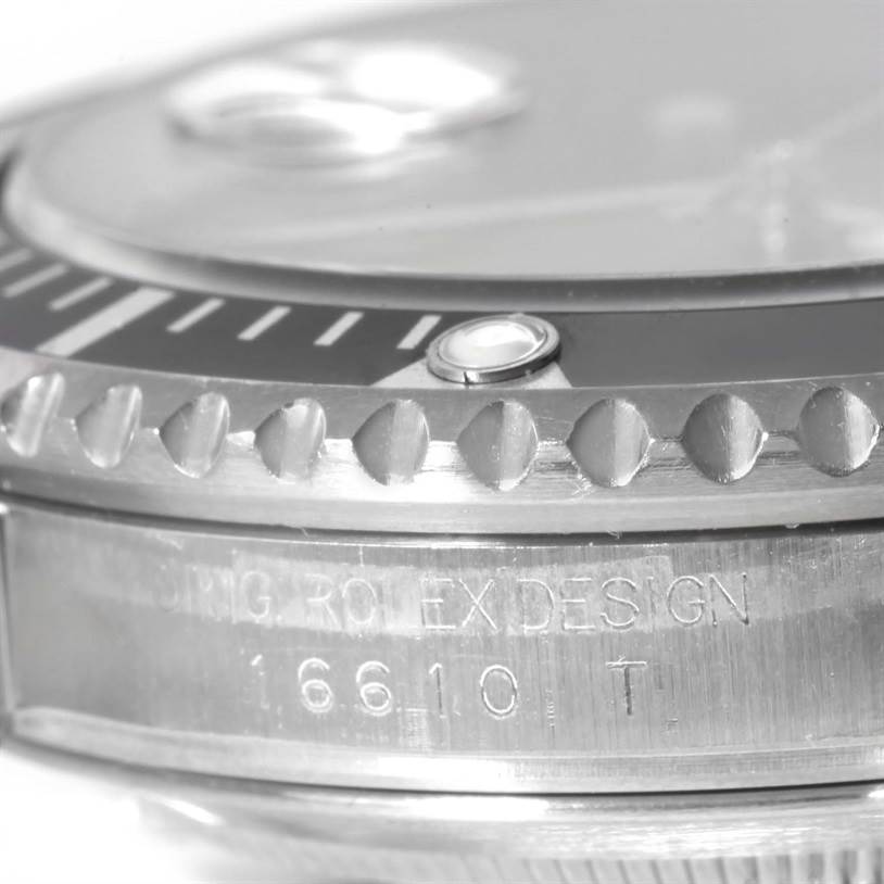 A macro shot of the side and bezel of a Rolex Submariner 16610 Men
s Stainless Steel Black Dial 16610 Men
s Stainless Steel Black Dial, showing the model number and "ROLEX DESIGN" engraving.