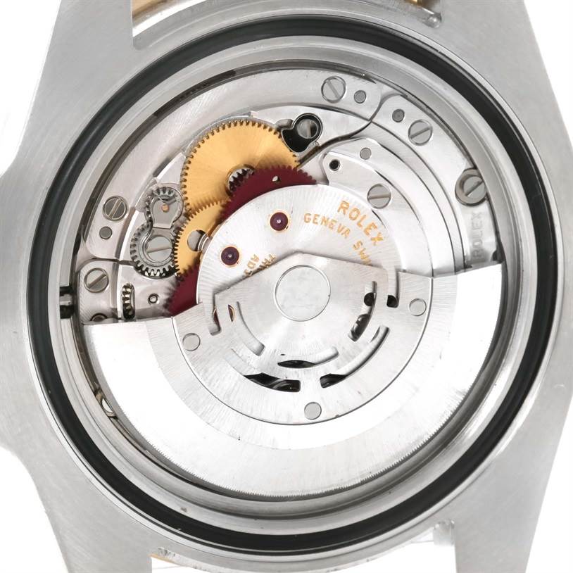 The image shows the back view of a Rolex Submariner 116613 Men's Steel and Gold (two tone) Blue Dial 116613 Men's Steel and Gold (two tone) Blue Dial watch, revealing its intricate internal mechanics and movement parts.