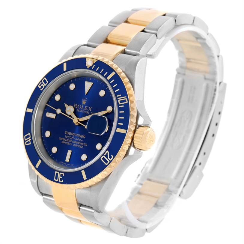 The image shows a Rolex Submariner 16613 Men's Steel and Gold (two tone) Blue Dial 16613 Men's Steel and Gold (two tone) Blue Dial watch at a three-quarter angle, highlighting the blue dial and two-tone bracelet.