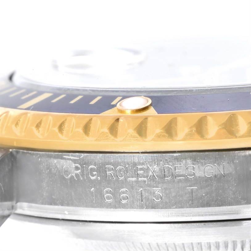 This close-up image shows the engraved side and bezel of a Rolex Submariner 16613 Men's Steel and Gold (two tone) Blue Dial 16613 Men's Steel and Gold (two tone) Blue Dial watch.