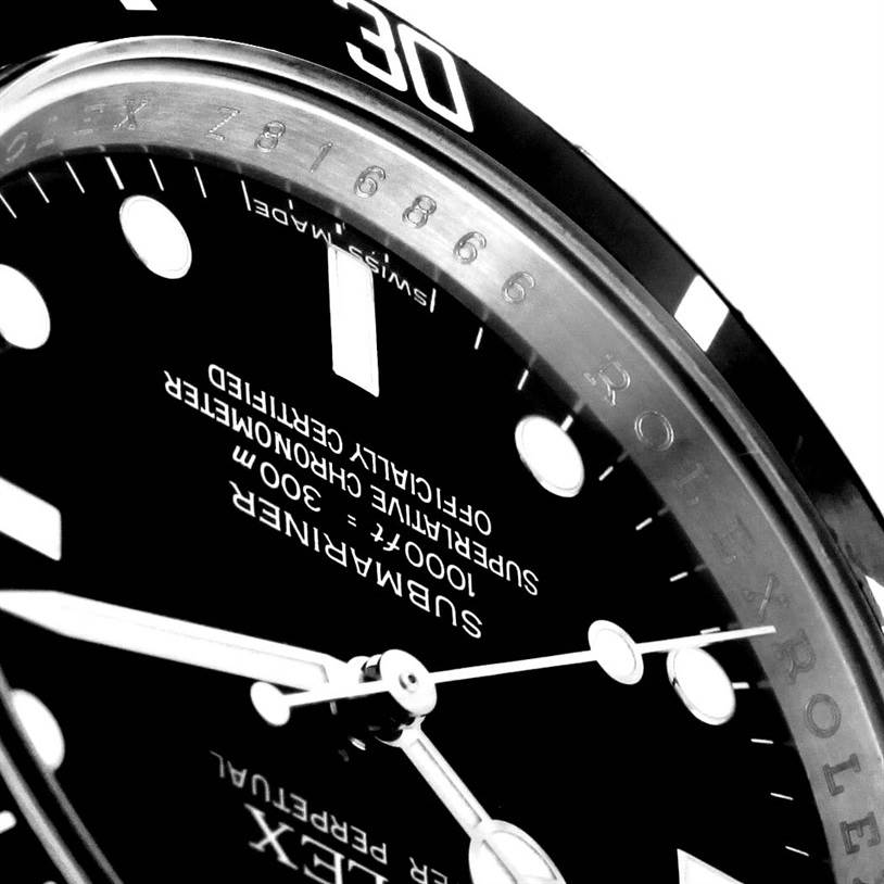 This close-up image of the Rolex Submariner 14060 Men
s Stainless Steel Black Dial 14060 Men
s Stainless Steel Black Dial watch showcases a segment of its dial, bezel, and part of the hands.