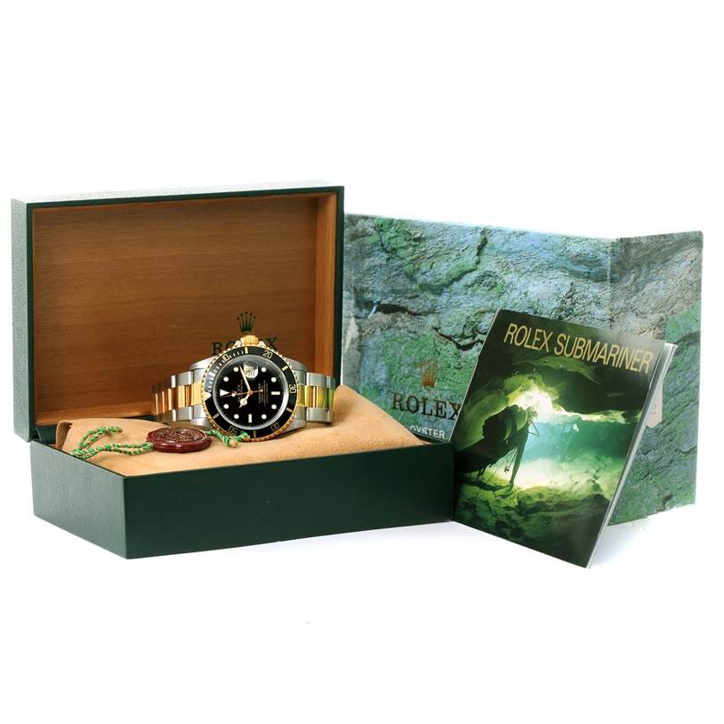 The image shows a Rolex Submariner 16613 Men's Steel and Gold (two tone) Black Dial 16613 Men's Steel and Gold (two tone) Black Dial watch in its box with a booklet and accessories placed beside it.