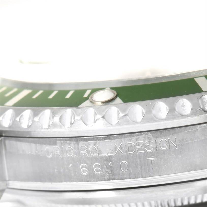 This close-up image shows the bezel and case of a Rolex Submariner 16610LV Men
s Stainless Steel Black Dial 16610LV Men
s Stainless Steel Black Dial watch, highlighting the engraving "ORIG. ROLEX DESIGN 16610T."