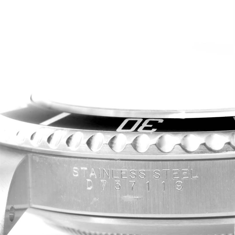 This image shows a close-up of the side of a Rolex Submariner 14060 Men
s Stainless Steel Black Dial 14060 Men
s Stainless Steel Black Dial watch, highlighting the bezel and stainless steel casing with engraved details.