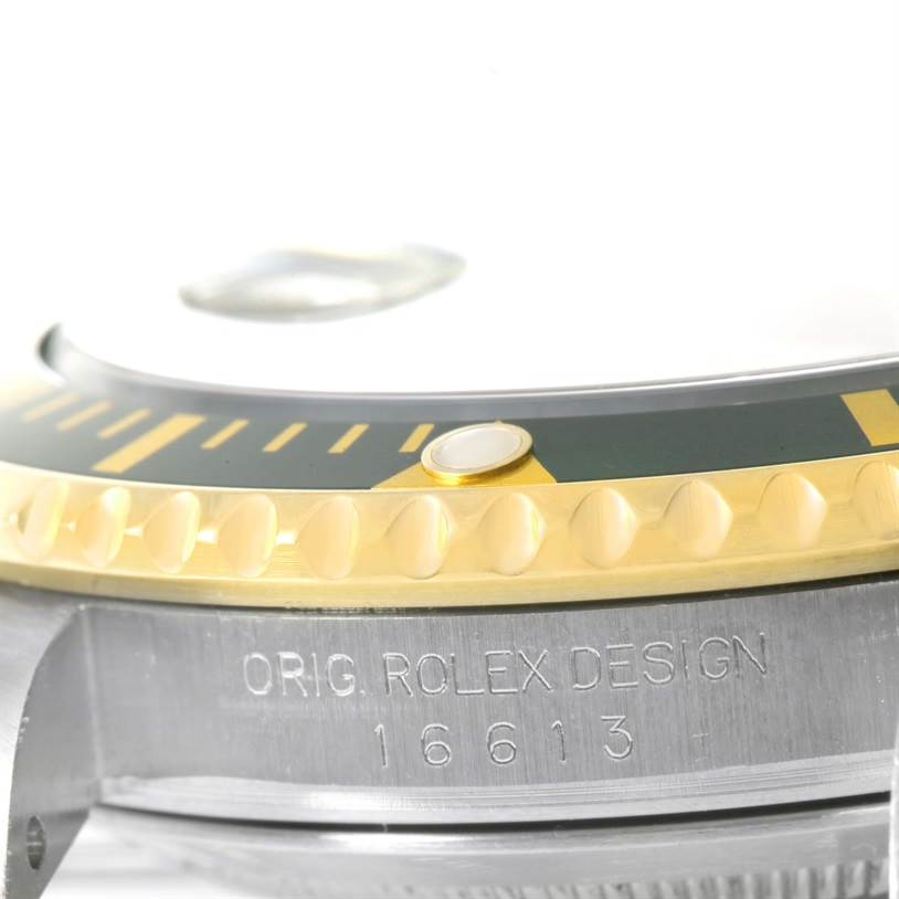 This close-up angle of the Rolex Submariner 16613 Men
s Steel and Gold (two tone) Black Dial 16613 Men
s Steel and Gold (two tone) Black Dial shows the bezel, case edge, and model number engraved on the side.