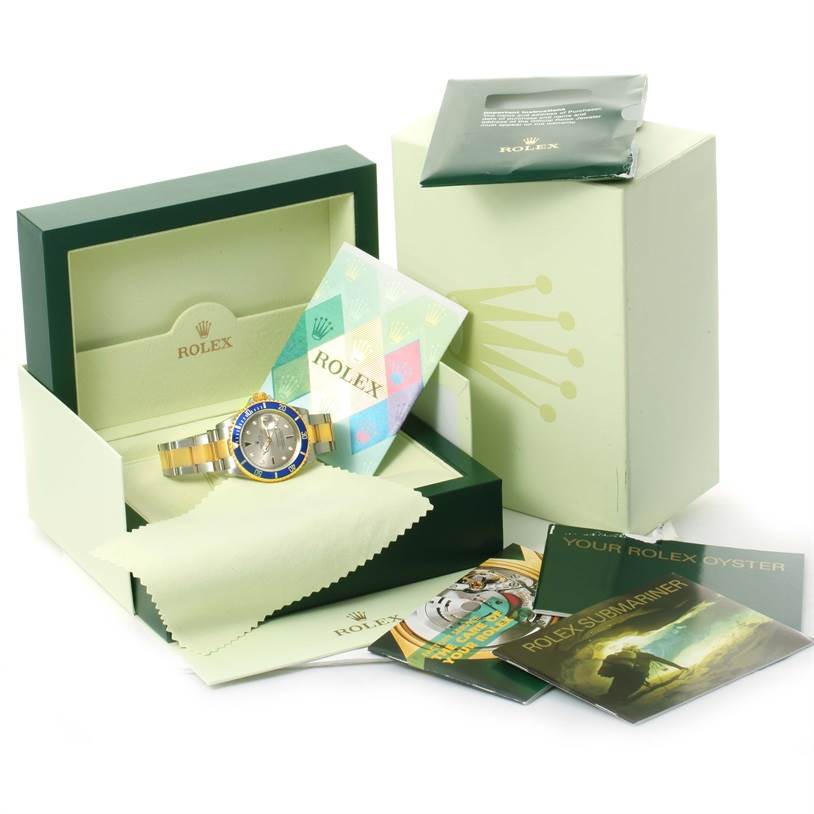 The image shows a Rolex Submariner 16613 Men's Steel and Gold (two tone) Grey Dial 16613 Men's Steel and Gold (two tone) Grey Dial watch with its box, manuals, warranty card, and accessories.