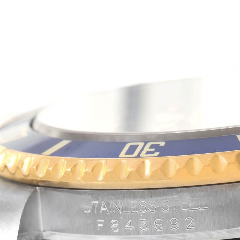 This image shows a close-up of the bezel and part of the case of a Rolex Submariner 16613 Men's Steel and Gold (two tone) Grey Dial 16613 Men's Steel and Gold (two tone) Grey Dial watch.