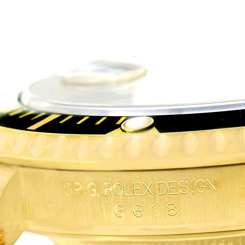 The image shows a close-up of the bezel, crystal, and engraved side of a Rolex Submariner 16618 Men
s Yellow Gold Black Dial 16618 Men
s Yellow Gold Black Dial watch.
