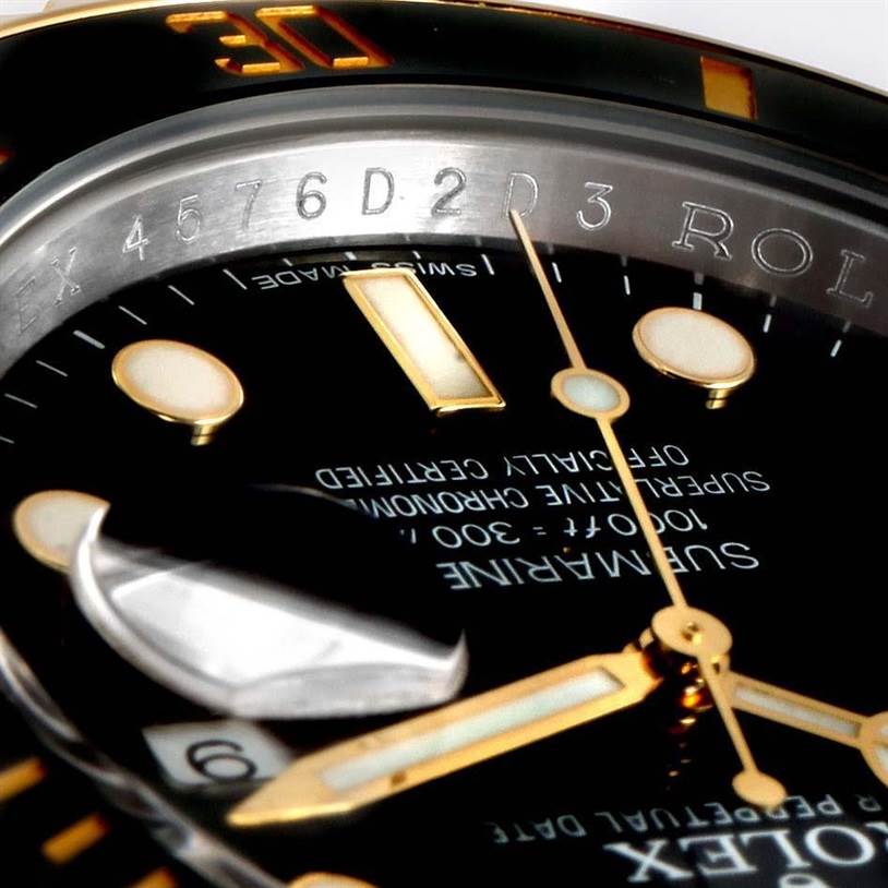 The image shows a close-up angled view of the Rolex Submariner 116613 Men
s Steel and Gold (two tone) Black Dial 116613 Men
s Steel and Gold (two tone) Black Dial watch
s dial and bezel with visible text and hour markers.