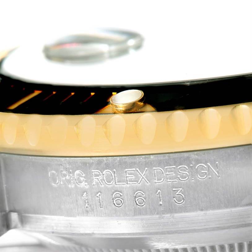The image shows a close-up of the bezel, crystal, and engraved serial number on a Rolex Submariner 116613 Men
s Steel and Gold (two tone) Black Dial 116613 Men
s Steel and Gold (two tone) Black Dial watch.