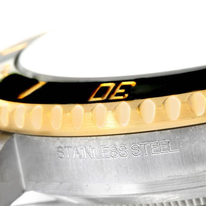 The image shows a close-up of the bezel and part of the case of a Rolex Submariner 116613 Men
s Steel and Gold (two tone) Black Dial 116613 Men
s Steel and Gold (two tone) Black Dial watch, highlighting the "STAINLESS STEEL" engraving.