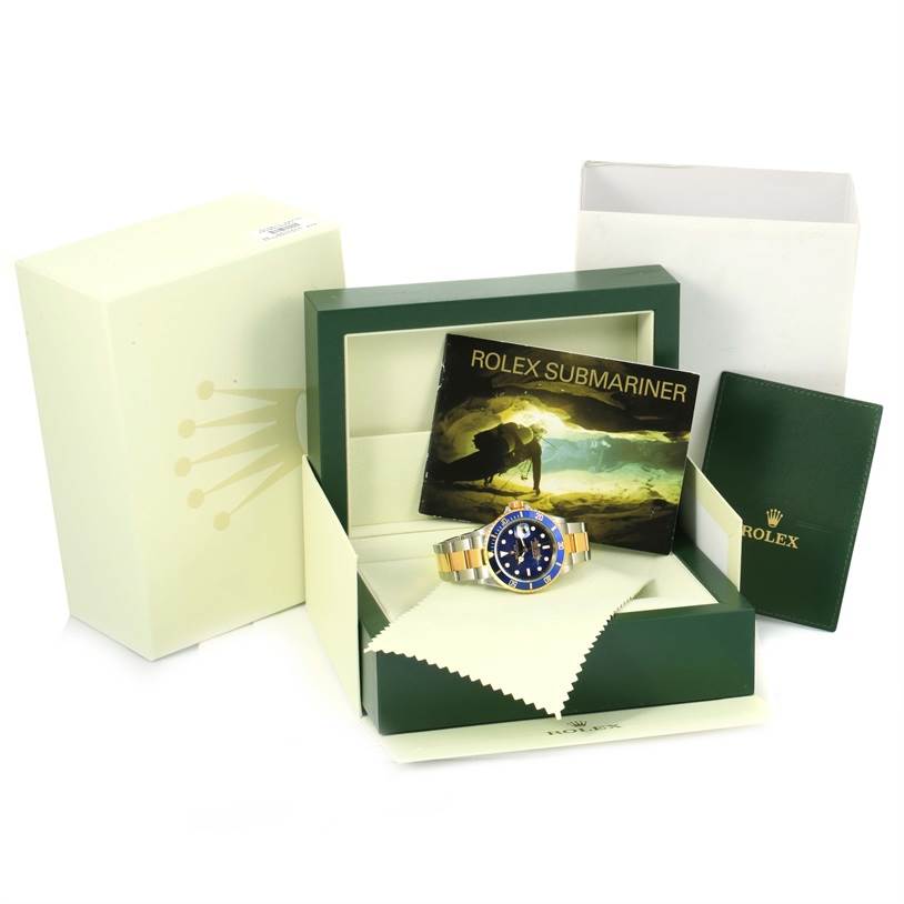 The image shows a Rolex Submariner 16613 Men
s Steel and Gold (two tone) Black Dial 16613 Men
s Steel and Gold (two tone) Black Dial watch in its open box with accompanying booklets and packaging.