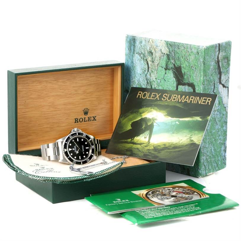 The image shows a Rolex Submariner 14060 Men
s Stainless Steel Black Dial 14060 Men
s Stainless Steel Black Dial watch, its box, tags, and accompanying booklets from an angled perspective.