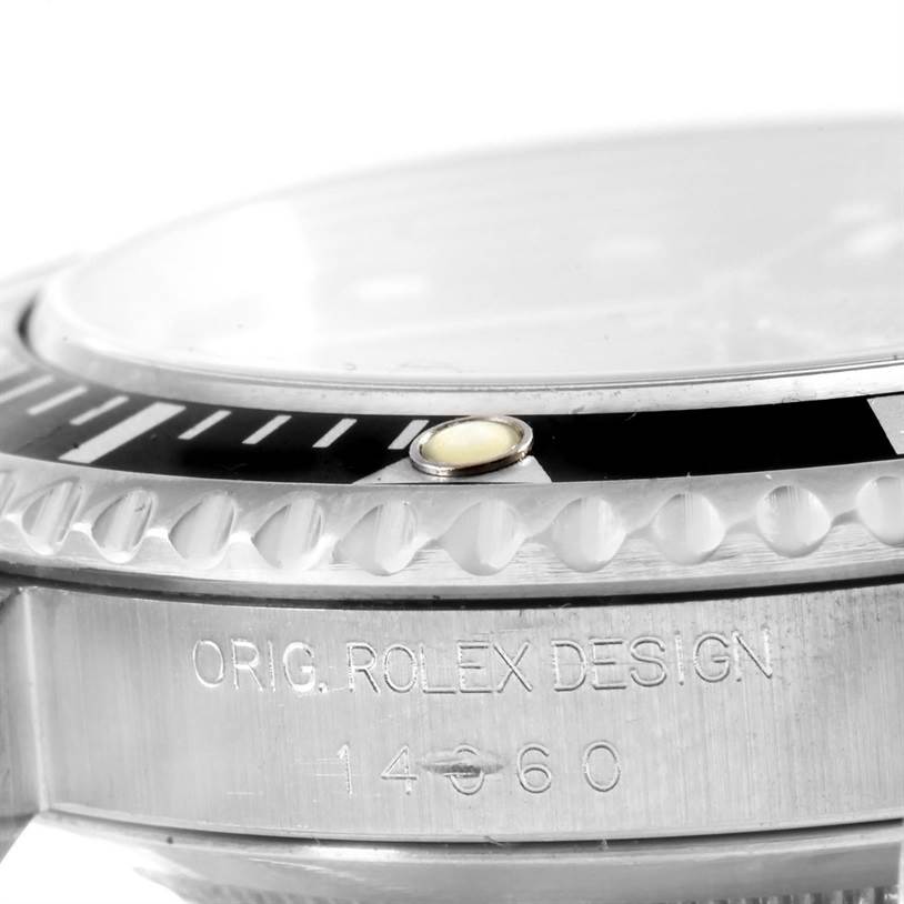 The image shows a close-up side view of a Rolex Submariner 14060 Men
s Stainless Steel Black Dial 14060 Men
s Stainless Steel Black Dial watch, focusing on the bezel and part of the case engraved with "ORIG. ROLEX DESIGN 14060."