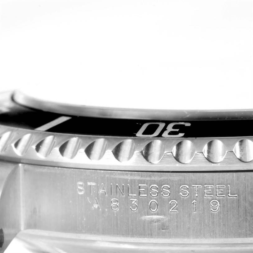 The image shows a close-up side view of a Rolex Submariner 14060 Men
s Stainless Steel Black Dial 14060 Men
s Stainless Steel Black Dial watch, highlighting its stainless steel bezel and case with serial number.