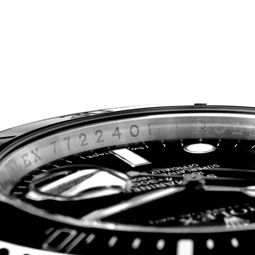 The image shows a close-up angle of a Rolex Submariner 116610 Men
s Stainless Steel Black Dial 116610 Men
s Stainless Steel Black Dial, focusing on the engraved serial number and part of the watch face.