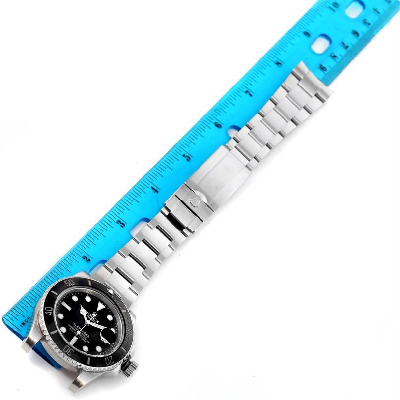 The image shows a Rolex Submariner 116610 Men
s Stainless Steel Black Dial 116610 Men
s Stainless Steel Black Dial watch, including the face, bezel, and bracelet, measured against a blue ruler.