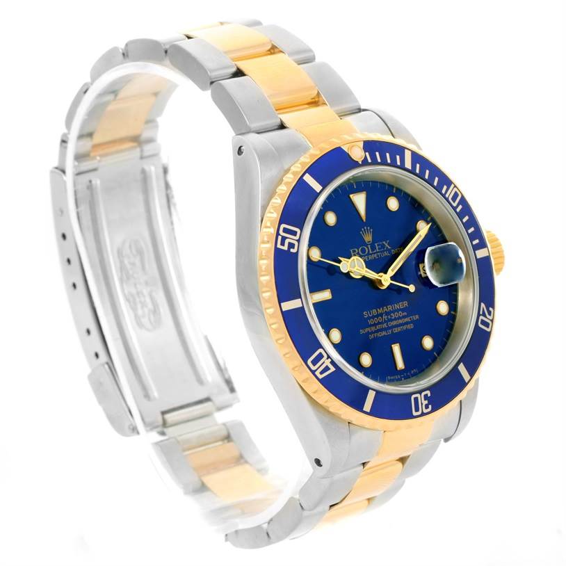 The Rolex Submariner 16613 Men
s Steel and Gold (two tone) Black Dial 16613 Men
s Steel and Gold (two tone) Black Dial watch is shown at a 3/4 angle, highlighting its blue dial, bezel, and two-tone bracelet.