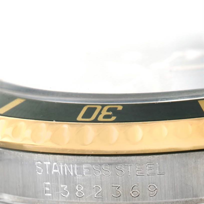 This image shows a close-up of the bezel and the engraved serial number on the side of a Rolex Submariner 16613 Men
s Steel and Gold (two tone) Black Dial 16613 Men
s Steel and Gold (two tone) Black Dial watch.