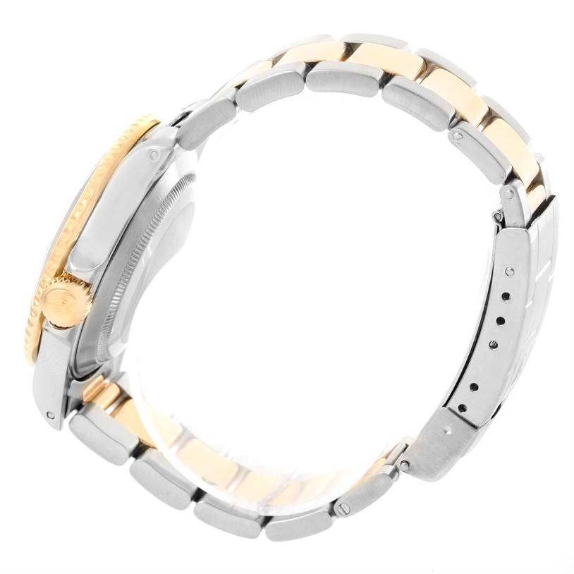 This side-angle view of the Rolex Submariner 16613 Men
s Steel and Gold (two tone) Black Dial 16613 Men
s Steel and Gold (two tone) Black Dial watch shows the two-tone bracelet, crown, and case.