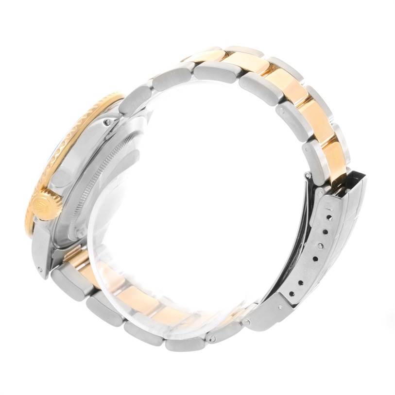 This image shows a side view of a Rolex Submariner 16803 Men's Steel and Gold (two tone) Blue Dial 16803 Men's Steel and Gold (two tone) Blue Dial watch featuring its crown, bezel, and stainless steel and gold bracelet.