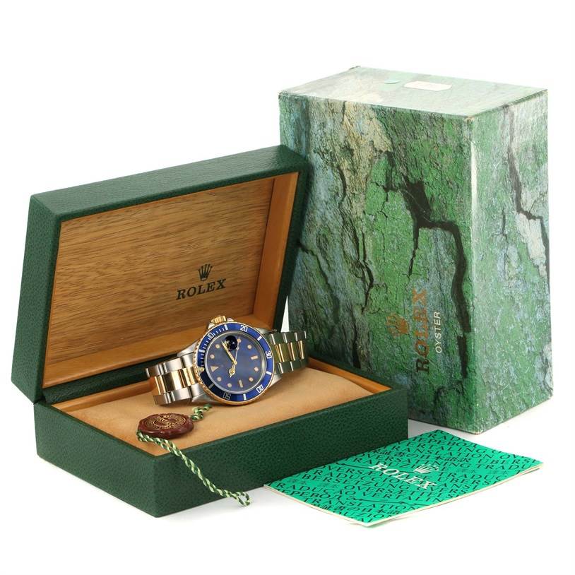 The image shows a Rolex Submariner 16803 Men's Steel and Gold (two tone) Blue Dial 16803 Men's Steel and Gold (two tone) Blue Dial watch in its open box, with the outer box and documentation nearby.