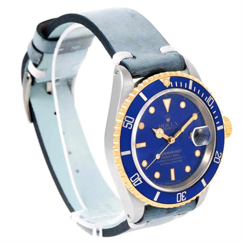 The image shows a Rolex Submariner 16613 Men's Steel and Gold (two tone) Blue Dial 16613 Men's Steel and Gold (two tone) Blue Dial watch angled to display its blue dial, gold bezel, and leather strap.