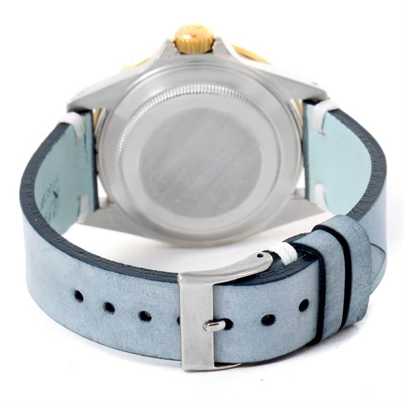 The image shows the backside of a Rolex Submariner 16613 Men's Steel and Gold (two tone) Blue Dial 16613 Men's Steel and Gold (two tone) Blue Dial watch with the case back and a blue leather strap.