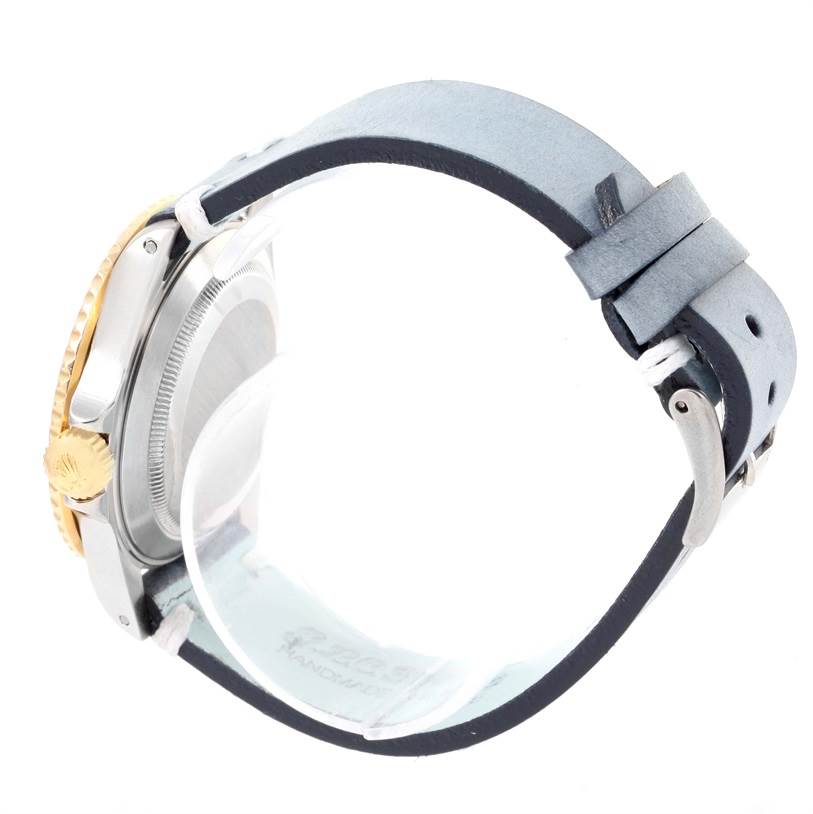 The image shows a side view of a Rolex Submariner 16613 Men's Steel and Gold (two tone) Blue Dial 16613 Men's Steel and Gold (two tone) Blue Dial model, highlighting its crown and a leather strap.