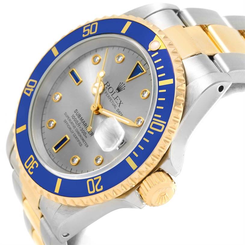 The image shows a partial side angle of a Rolex Submariner 16613 Men
s Steel and Gold (two tone) Grey Dial 16613 Men
s Steel and Gold (two tone) Grey Dial watch, highlighting the blue bezel, crown, and part of the bracelet.