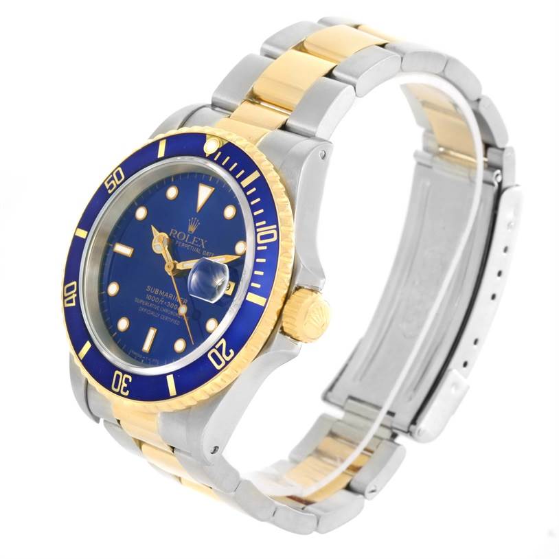 The image shows a steel and gold Rolex Submariner 16613 Men
s Steel and Gold (two tone) Black Dial 16613 Men
s Steel and Gold (two tone) Black Dial watch at a three-quarter angle highlighting its blue dial, bezel, case, and bracelet.