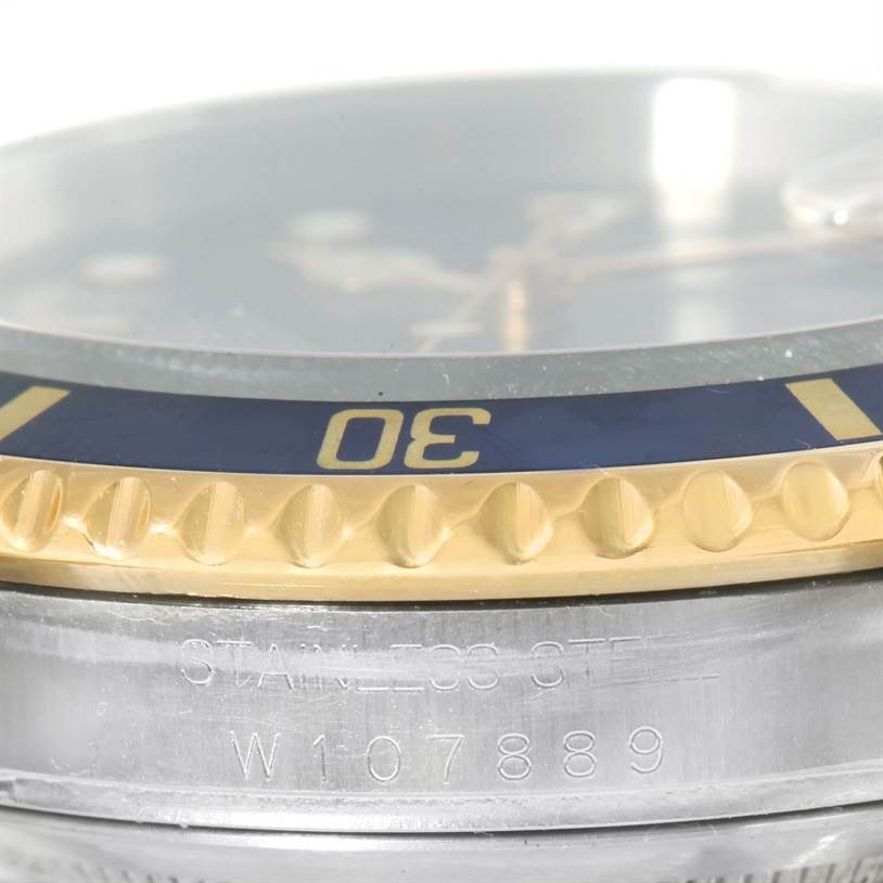 Close-up of a Rolex Submariner 16613 Men
s Steel and Gold (two tone) Black Dial 16613 Men
s Steel and Gold (two tone) Black Dial showing the bezel, crystal, and part of the case with a visible serial number.