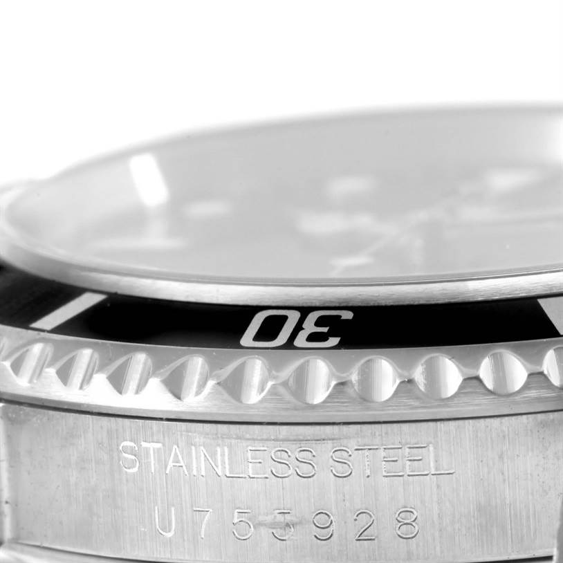 This close-up image of a Rolex Submariner 14060 Men
s Stainless Steel Black Dial 14060 Men
s Stainless Steel Black Dial watch shows part of the bezel, the "30" minute marker, and the engraved stainless steel case.
