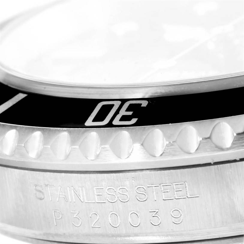 The image shows a close-up of the bezel and part of the stainless steel case back of the Rolex Submariner 16610 Men's Stainless Steel Black Dial 16610 Men's Stainless Steel Black Dial.