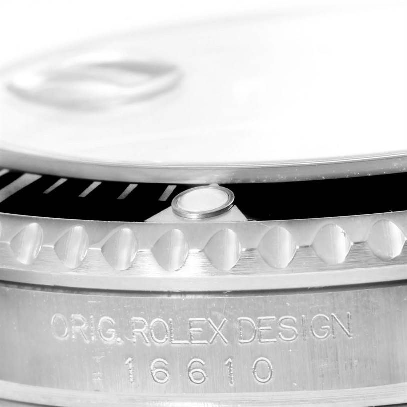 This close-up image of a Rolex Submariner 16610 Men's Stainless Steel Black Dial 16610 Men's Stainless Steel Black Dial shows the engraved bezel and "ORIG. ROLEX DESIGN" inscription with the model number 16610.