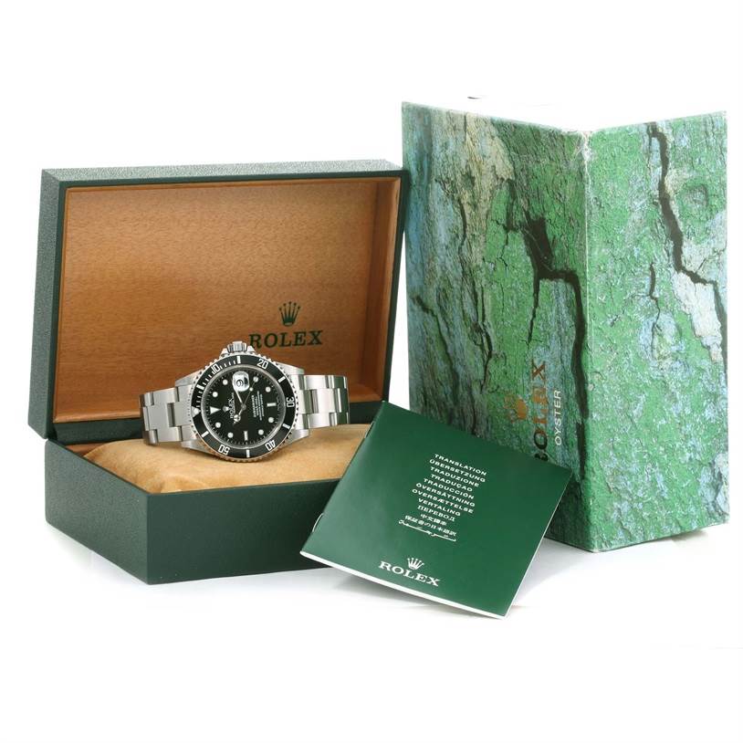 This image shows a Rolex Submariner 16610 Men's Stainless Steel Black Dial 16610 Men's Stainless Steel Black Dial watch in its open box with the outer box and booklet beside it.