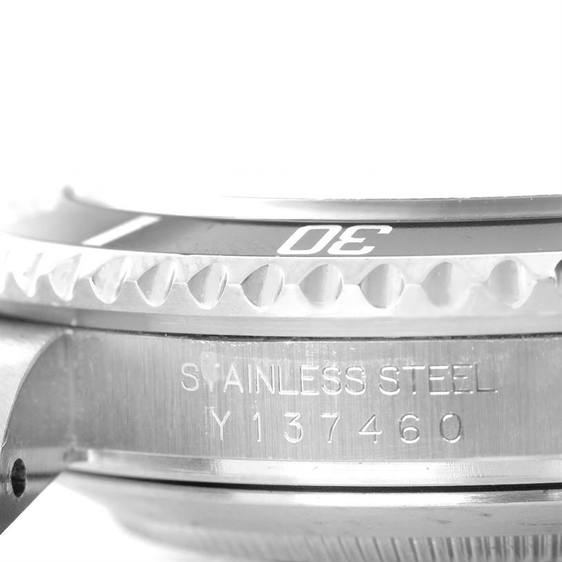 This close-up image of a Rolex Submariner 16610 Men
s Stainless Steel Black Dial 16610 Men
s Stainless Steel Black Dial watch shows the side view of the bezel and case with a visible serial number.