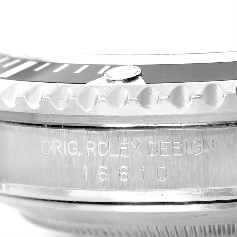 This close-up image of the Rolex Submariner 16610 Men
s Stainless Steel Black Dial 16610 Men
s Stainless Steel Black Dial watch shows part of its bezel and the engraved case with the model number 16610.