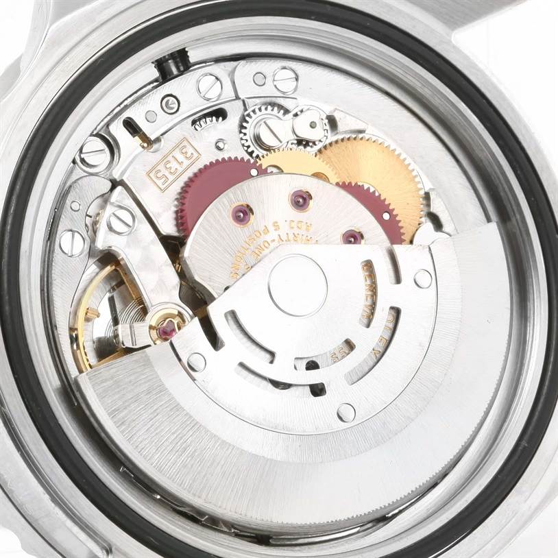 The image shows a close-up of the movement mechanism of a Rolex Submariner 16610 Men
s Stainless Steel Black Dial 16610 Men
s Stainless Steel Black Dial watch, highlighting gears and components.