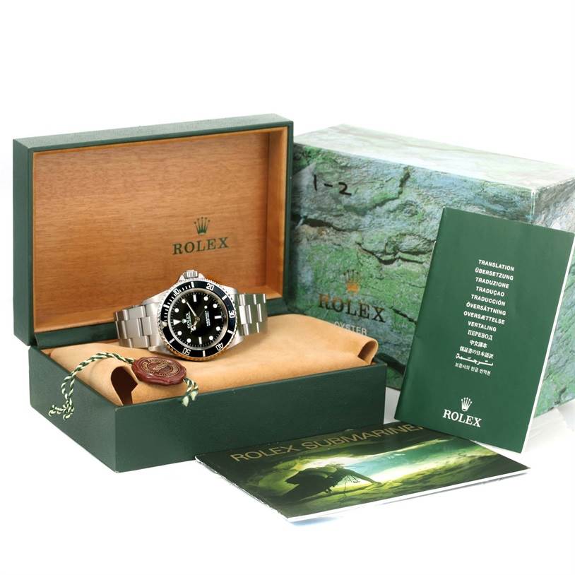 The image shows the Rolex Submariner 14060 Men
s Stainless Steel Black Dial 14060 Men
s Stainless Steel Black Dial watch in its open box along with a booklet and other accessories.