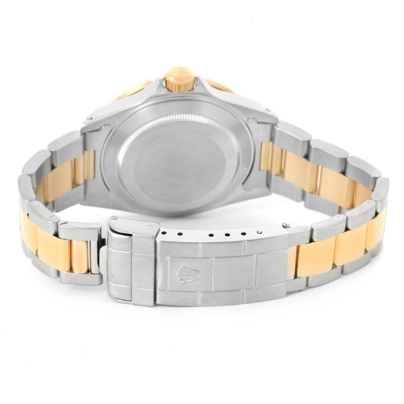 The image shows the back case and bracelet of a Rolex Submariner 16613 Men's Steel and Gold (two tone) Grey Dial 16613 Men's Steel and Gold (two tone) Grey Dial, with stainless steel and gold links.