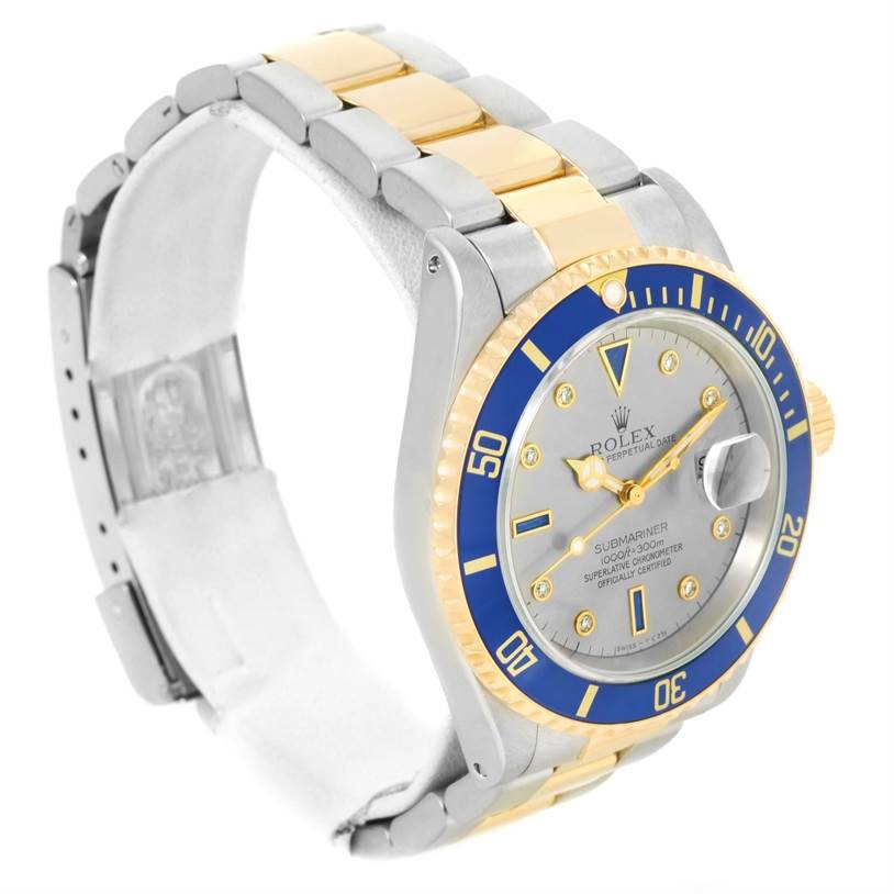 The image shows a Rolex Submariner 16613 Men's Steel and Gold (two tone) Grey Dial 16613 Men's Steel and Gold (two tone) Grey Dial watch at an angle highlighting its blue bezel, dial, and metal bracelet.