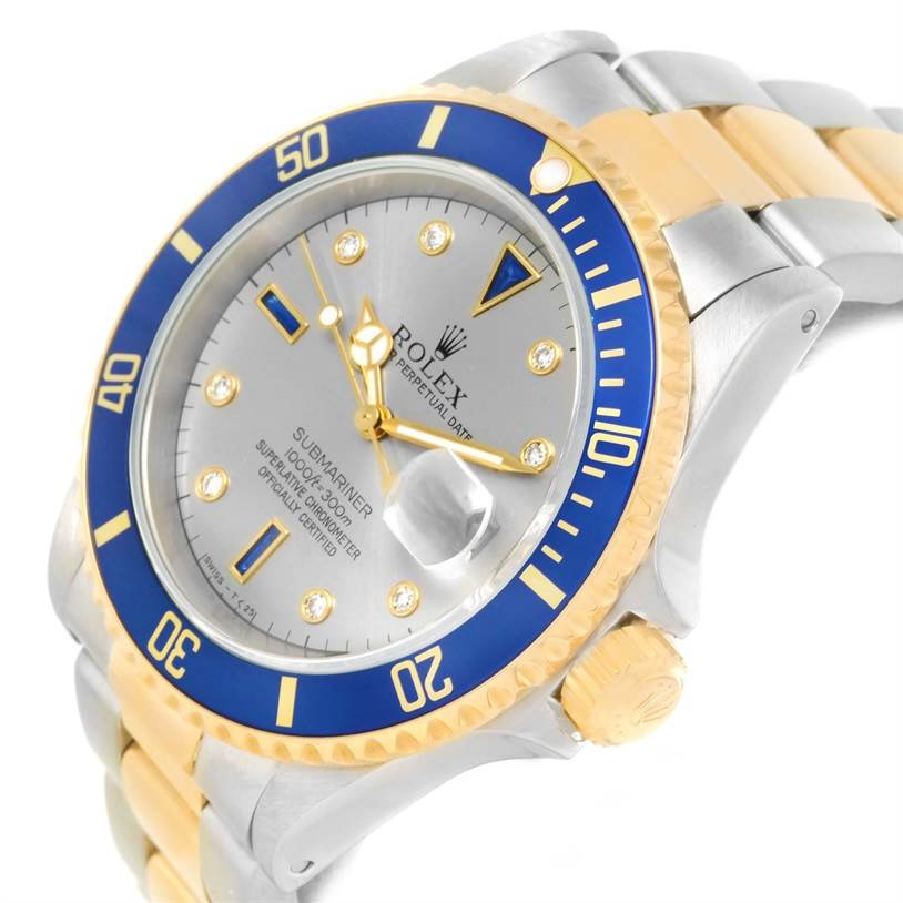 The image shows a Rolex Submariner 16613 Men's Steel and Gold (two tone) Grey Dial 16613 Men's Steel and Gold (two tone) Grey Dial watch at a slight angle, highlighting its bezel, dial, crown, and part of the bracelet.