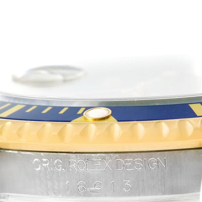 The image shows a close-up of the bezel and engraved details on the case side of a Rolex Submariner 16613 Men's Steel and Gold (two tone) Grey Dial 16613 Men's Steel and Gold (two tone) Grey Dial.