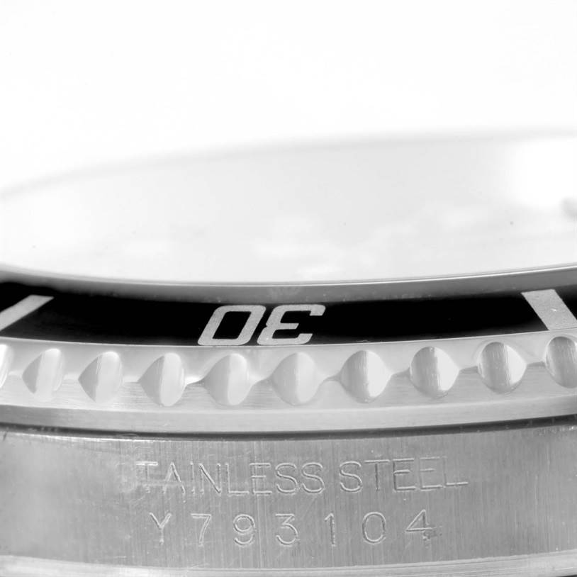 Close-up of the Rolex Submariner 16610 Men
s Stainless Steel Black Dial 16610 Men
s Stainless Steel Black Dial showing the bezel edge, "30" minute marker, and part of the stainless steel case with serial number.