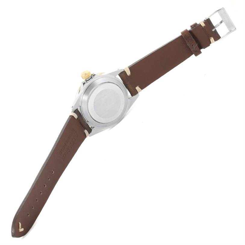 The image shows the back and sides of a Rolex Submariner 16803 Men
s Steel and Gold (two tone) Black Dial 16803 Men
s Steel and Gold (two tone) Black Dial watch with a brown leather strap, including the crown and clasp.