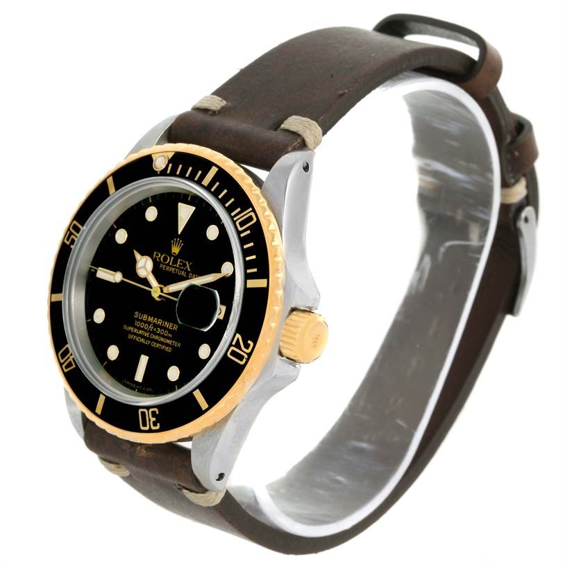 The Rolex Submariner 16803 Men
s Steel and Gold (two tone) Black Dial 16803 Men
s Steel and Gold (two tone) Black Dial watch shown is at a slight angle, displaying the face, bezel, crown, and leather strap.